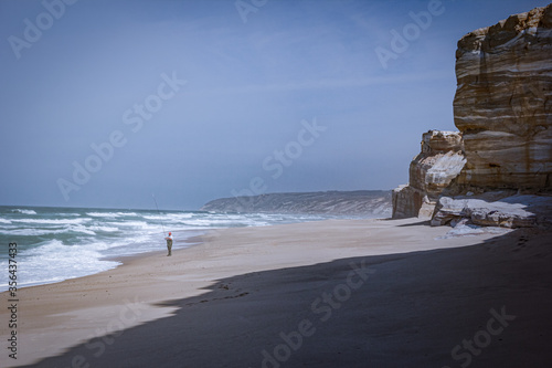 fisherman on the beach near by the coulred cliffs photo