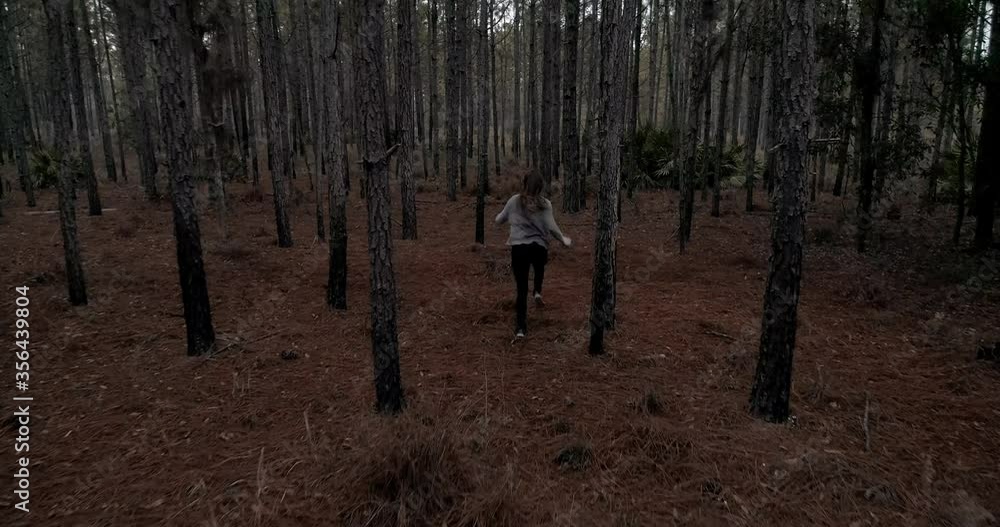 Woman running scared in dark forest, being chased