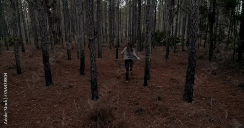 Woman running scared in dark forest, being chased
