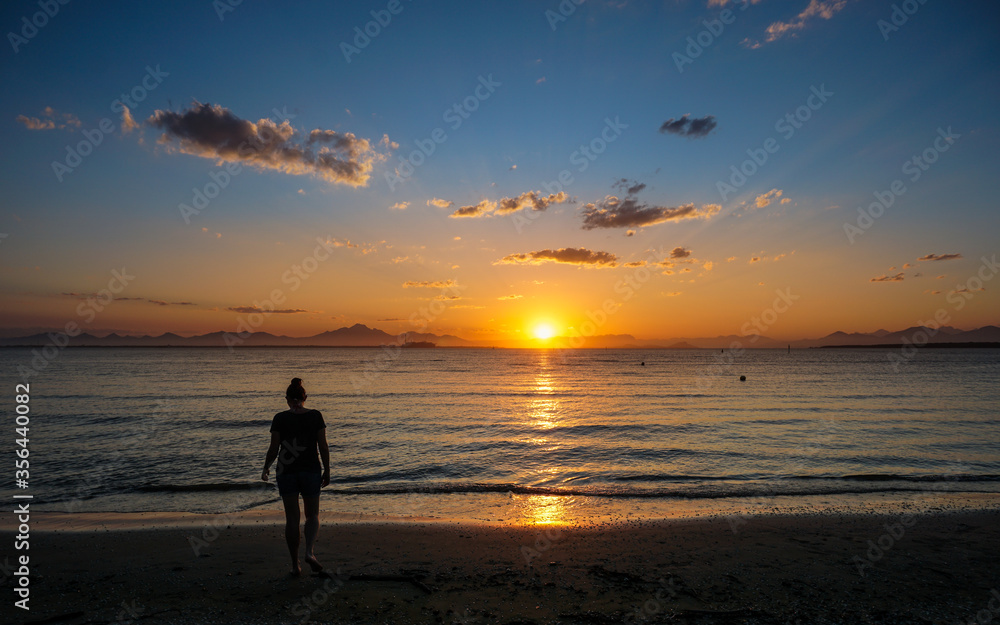 Woman contemplating a beautiful sunset in Ilha do Mel, Paraná, Brazil