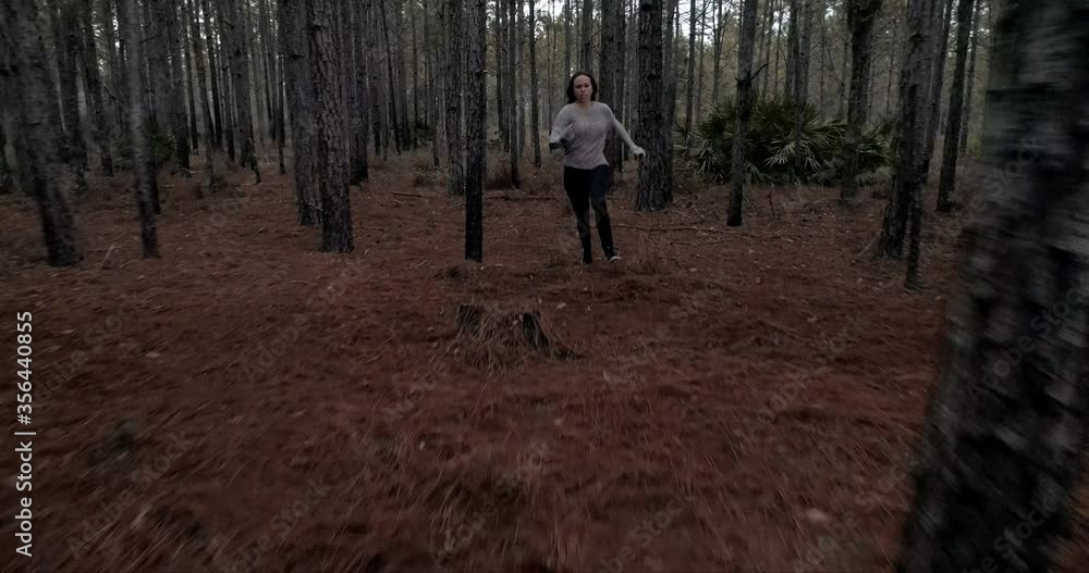 Woman running scared in dark forest, being chased