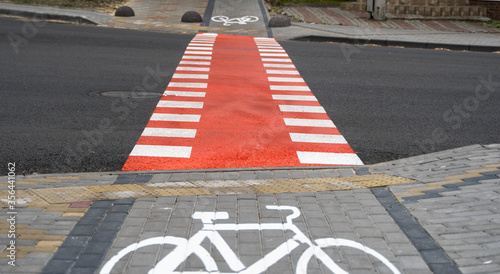 Cycling path with a symbol of bike on a ground through avtomobile road. Bike path in a modern city. photo