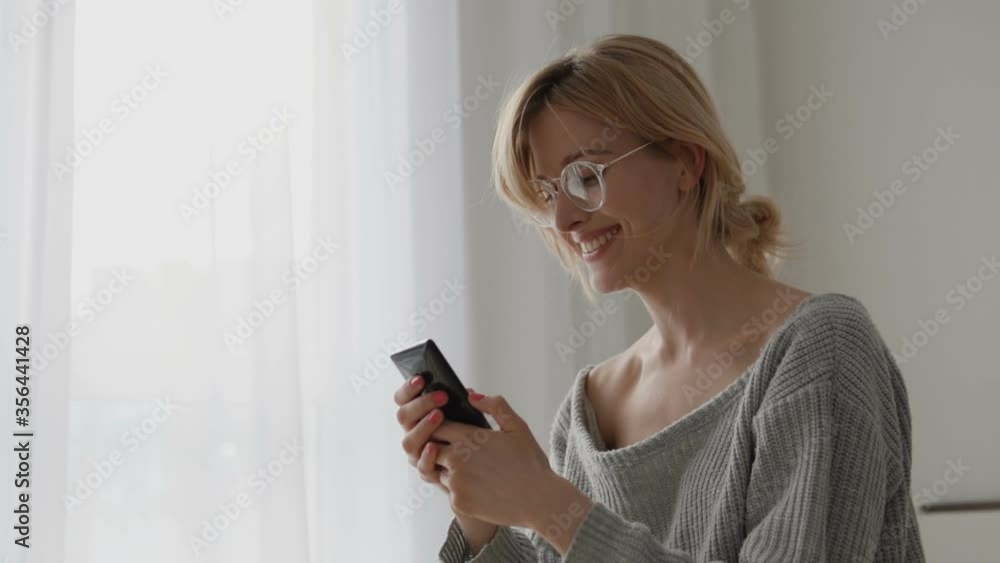 Happy woman looking at modern gadget and laughing, communication technology Happy woman looking at modern gadget and laughing, communication technology