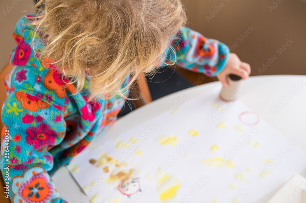 Cute blonde girl paitining with many colors using paintbrush and fingers. Cute blonde girl paitining with many colors using paintbrush and fingers.