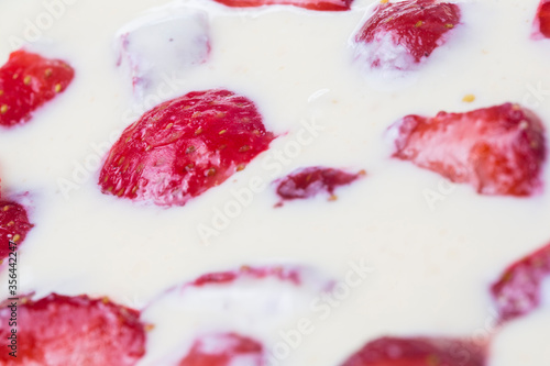 filled frame background wallpaper shot of strawberries on the surface of a milky white vanilla cheese cake cream liquid