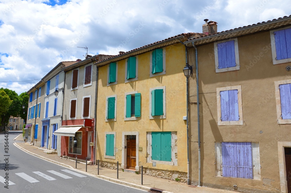 Old traditional houses with colorful shutters near the medieval village of Reillanne in Provence Alpes Cote d Azur on lavender route, France, crosswalk in front Old traditional houses with colorful shutters near the medieval village of Reillanne in Provence Alpes Cote d Azur on lavender route, France, crosswalk in front
