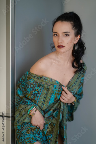 beautiful happy girl in a green housecoat against the gray walls