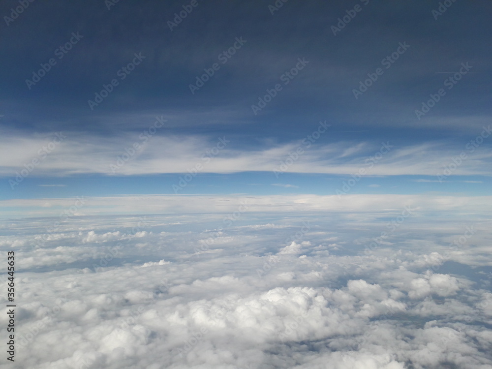 Blue sky above the clouds, lots of cumulus clouds.