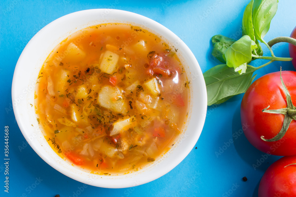 Cabbage and tomato soup with chicken.blue background. Next to the ingredients Cabbage and tomato soup with chicken.blue background. Next to the ingredients