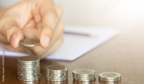 Hand of businessman put a top of coin stacking for saving money concept idea.