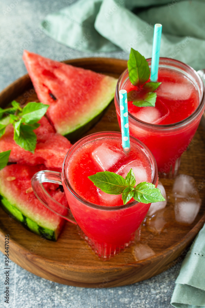 Cold Watermelon Smoothie. Summer Watermelon drink and slices of watermelon on a light stone table. Cold Watermelon Smoothie. Summer Watermelon drink and slices of watermelon on a light stone table.