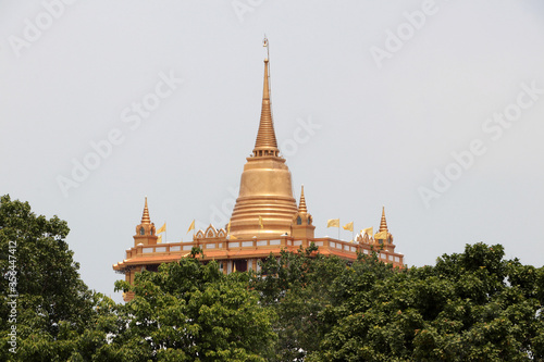 Pagoda looking through the treetops. The Golden Mount is a replica of a mountain pagoda situated in the Wat Saket temple. Bangkok, Thailand.