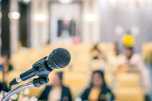 Microphone on stage in seminar room or speaking conference hall or educational seminar classroom with abstract blurred background.