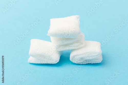 White gauze pads on  blue background. Materials for dental surgery. Close up