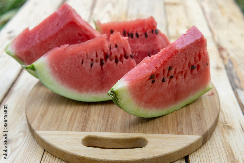 Fresh ripe sliced watermelon on wooden rustic background