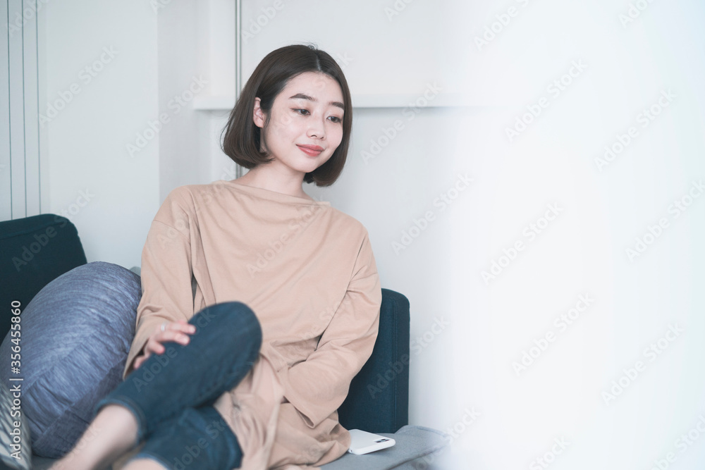 ステイホーム・ソファでリラックスする女性 ステイホーム・ソファでリラックスする女性