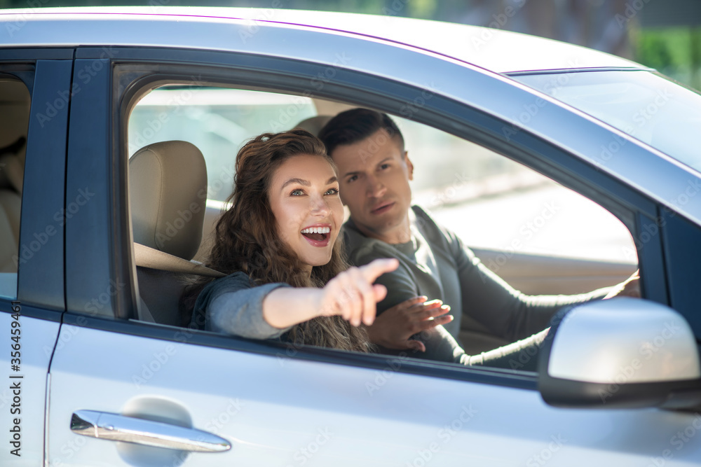 Young couple sitting in the car and looking at something