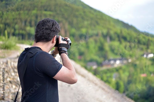Man photographing with professional photo camera beautiful landscape on the top of the mountain