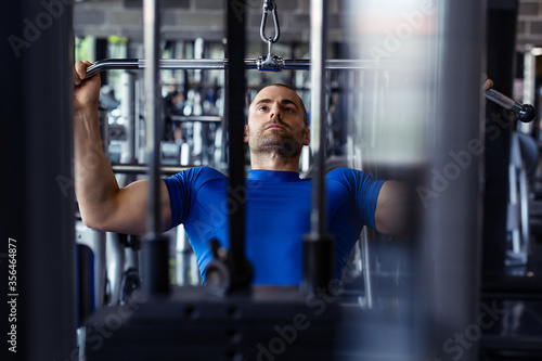 Fit man exercising at the gym on a machine.