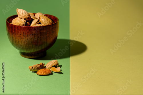 Bowl of almonds on green and yellow photo