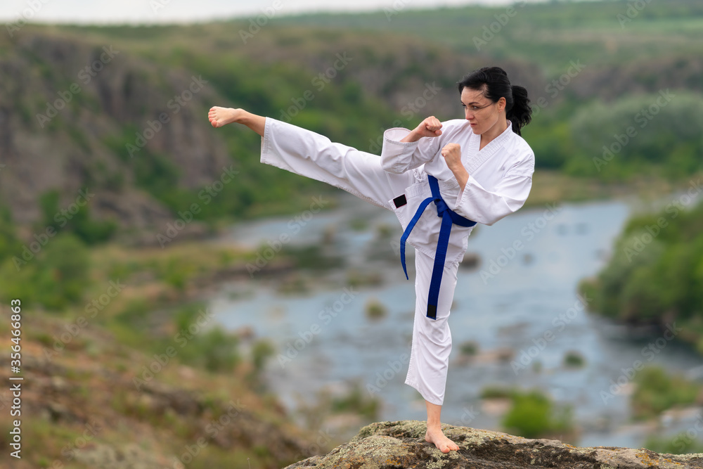 Young woman practicing kickboxing outdoors
