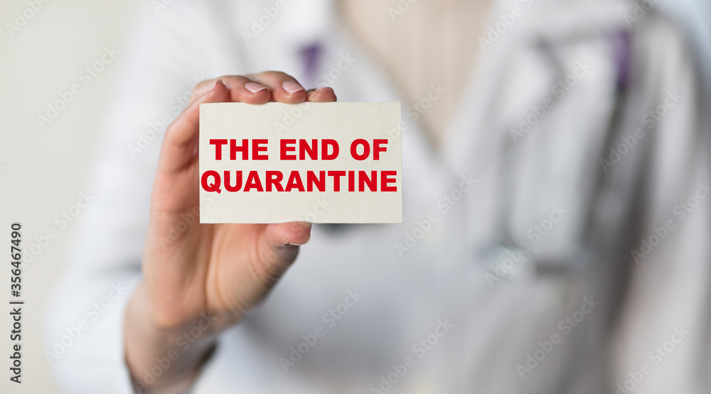 The doctor hold white card with text THE END OF QUARANTINE. Coronavirus outbreak concept. Medical concept The doctor hold white card with text THE END OF QUARANTINE. Coronavirus outbreak concept. Medical concept