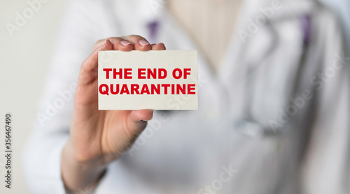 Photos The doctor hold white card with text THE END OF QUARANTINE