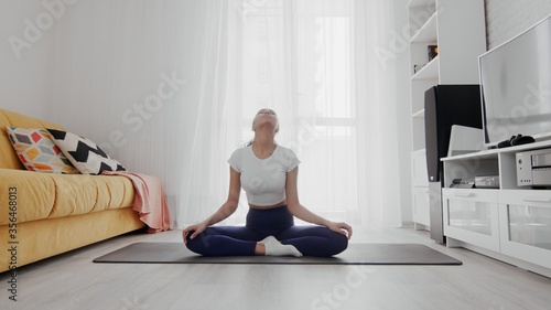 Slim sporty african american woman practicing yoga on a mat. Woman warms up before training
