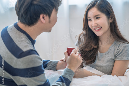 Happy asian couples, The young man gave a gift to his lover, The girl is excited and happy when receiving the gift.