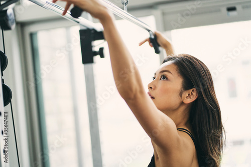 ラットプルマシンでトレーニングをする日本人女性 photo