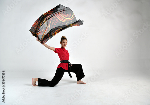 beautiful girl in black and red dancing with a combat scarf