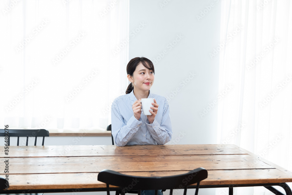 テーブルでお茶を飲んでいる女性 テーブルでお茶を飲んでいる女性