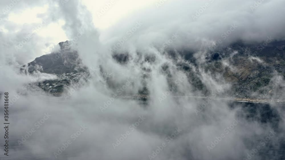 Drone Shot of Thick Fog Covering the Sea and Coastline by the Mountains Drone Shot of Thick Fog Covering the Sea and Coastline by the Mountains