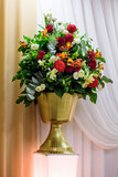 Beautiful flowers in the golden vase in wedding day