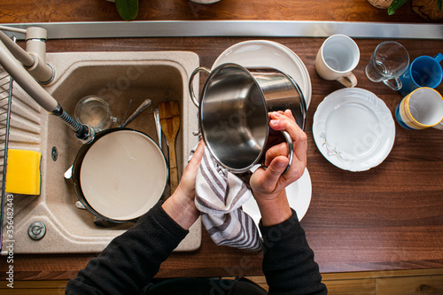 Fotografie Woman wiping dishware with cotton towel in kitchen