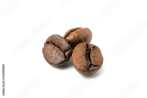 Foto three freshly roasted coffee beans isolated on a white background