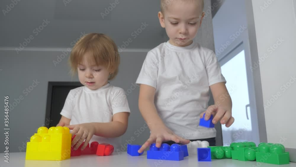 happy family boy and girl a collect constructor teamwork. kids play toys concept. children brother and sister play indoors collect house from constructor lifestyle happy family boy and girl a collect constructor teamwork. kids play toys concept. children brother and sister play indoors collect house from constructor lifestyle