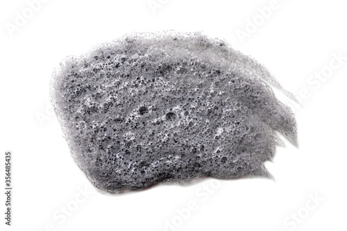 Gray smear of Korean bubble mask on white background isolated. Acne treatment, cosmetology, dermatology. Beauty product. Black clay smudged. Skin care, organic cosmetics. Carbonic acid. Closeup. © Яна Куница