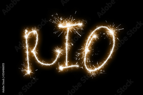 The inscription Rio on a black background with sparklers using a simulated long exposure.