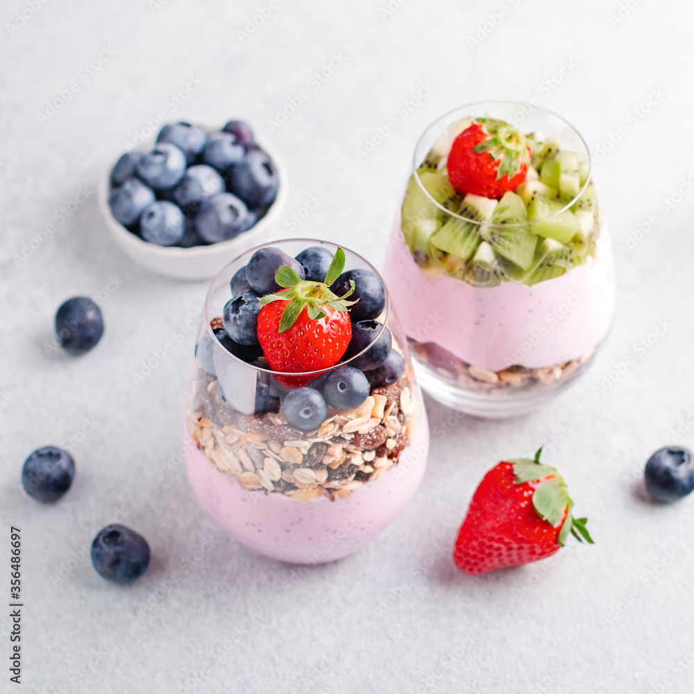 Chia seeds pudding with granola, blueberry and strawberry in glasses. Yogurt with chia seeds, berries, kiwi and muesli for healthy breakfast, copy space Chia seeds pudding with granola, blueberry and strawberry in glasses. Yogurt with chia seeds, berries, kiwi and muesli for healthy breakfast, copy space
