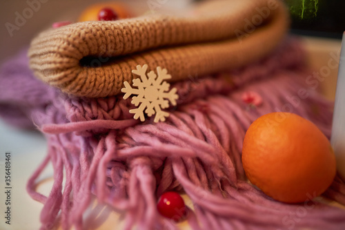 Photo for the New Year card. New Year's composition. View from above. Warm knitted scarf in purple. Tangerines lie on a scarf. Christmas composition with tangerines and a scarf.