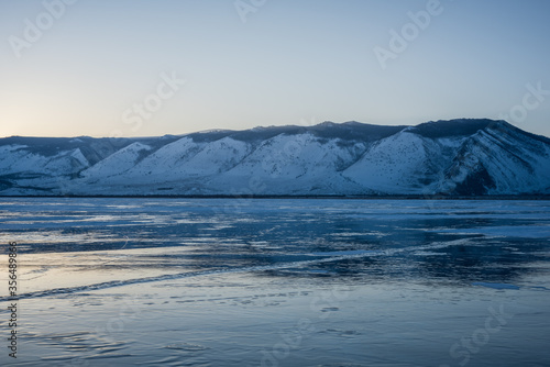 Fototapeta Naklejka Na Ścianę i Meble -  Early morning on the ice of lake Baikal against the background of mountains and ice