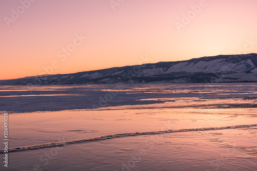Early morning on the ice of lake Baikal against the background of mountains and ice © zhuxiaophotography
