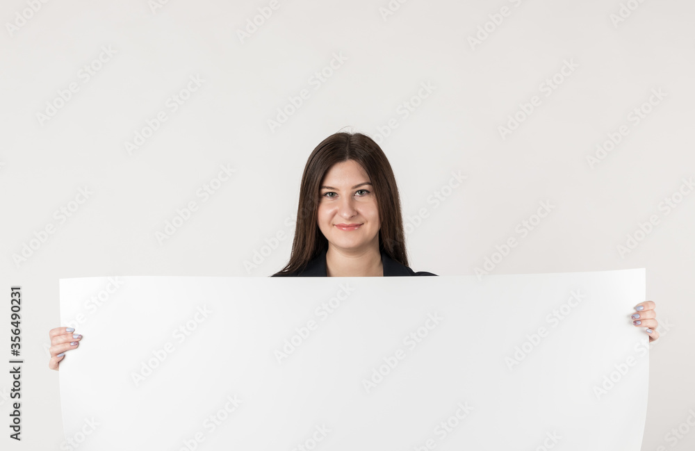 Young attractive woman is holding white paper. Young attractive woman is holding white paper.
