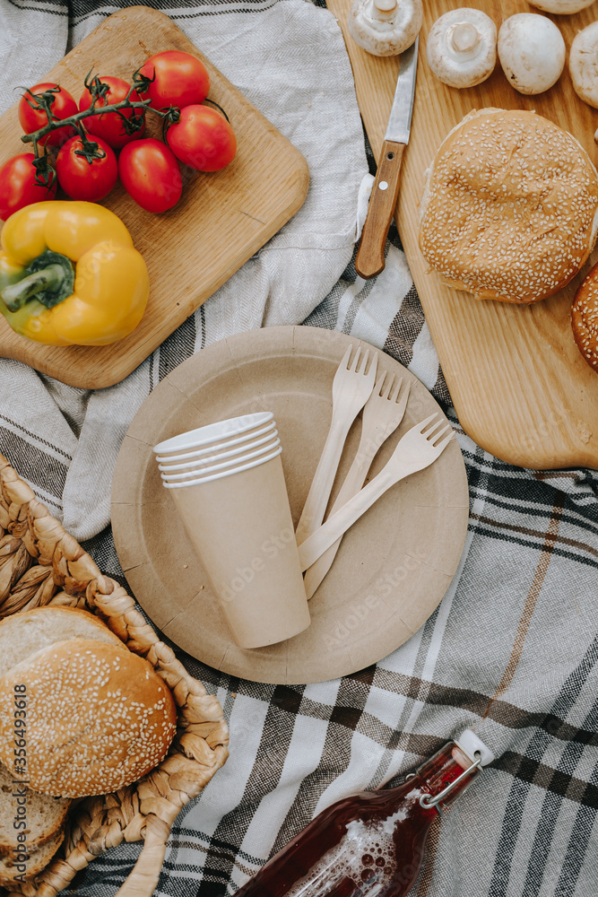 Fresh picnic food on a plaid. Peppers, tomatoes, lettuce, bread. Craft plates, glasses and wooden forks. High quality photo Fresh picnic food on a plaid. Peppers, tomatoes, lettuce, bread. Craft plates, glasses and wooden forks. High quality photo