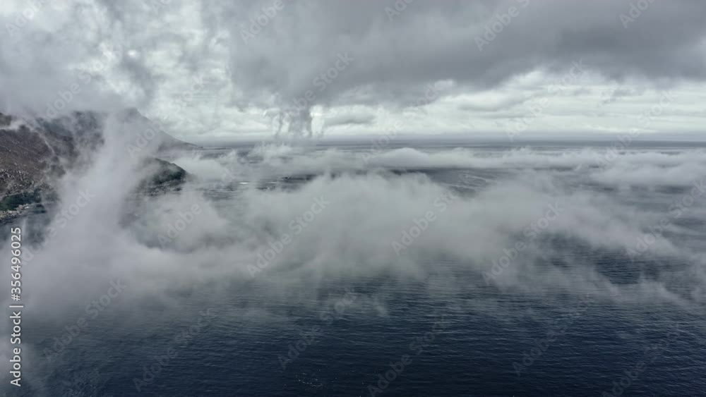 Slowmo Drone Shot of Deep Blue Seas and Mountain Behind Fog Slowmo Drone Shot of Deep Blue Seas and Mountain Behind Fog