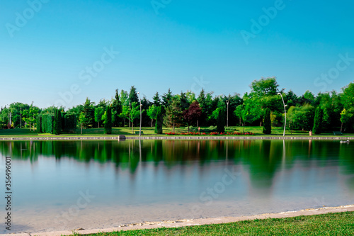 Scenic view natural park. Eskisehir, Turkey. The river flowing through the city. Reflections on the water. Colorful landscape. Sunny and windy day. Long exposure.