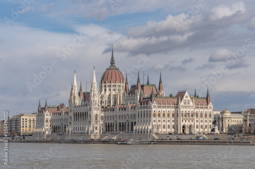 Hungarian Parliament facing Danube with clouds overhead in Budapest winter morning