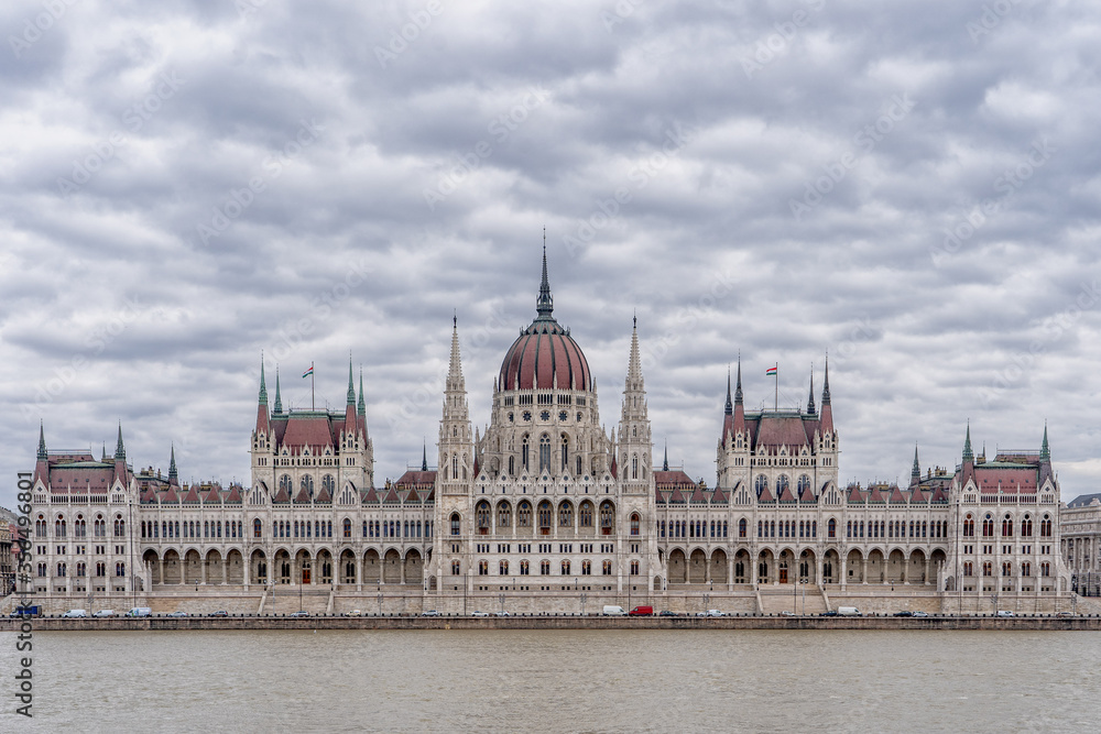 Fototapeta premium Hungarian Parliament facing Danube with clouds overhead in Budapest winter morning