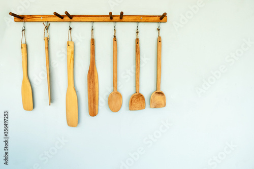 many sizes of wooden spoon hanging on the wall
